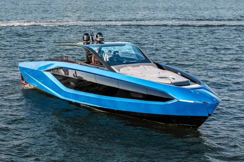 Aspen And Delilah Yacht Photos Pics 2023 Tecnomar 63 Lamborghini yacht cruising on open water, sleek blue design.