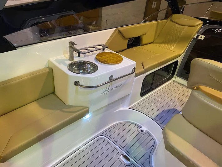  Yacht Photos Pics 2024 Hanover 305 boat interior with beige seating and compact sink area.