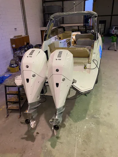  Yacht Photos Pics 2024 Hanover 305 boat with dual outboard engines in a warehouse setting.