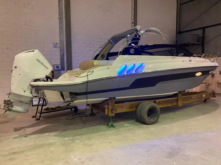  Yacht Photos Pics 2024 Hanover 305 boat with Mercury outboard engine in a warehouse setting.