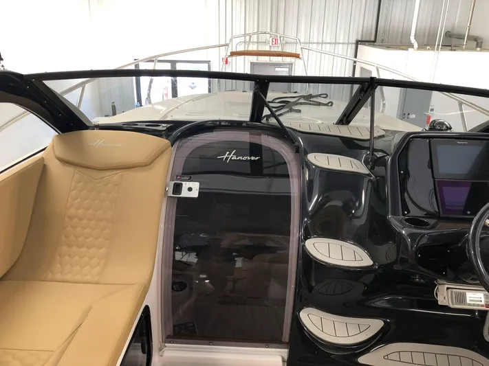  Yacht Photos Pics 2024 Hanover 305 boat interior with tan seating and sleek black dashboard.
