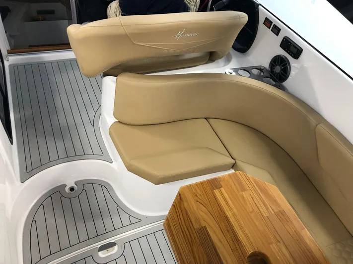  Yacht Photos Pics 2024 Hanover 305 boat interior with beige seating and wooden table.