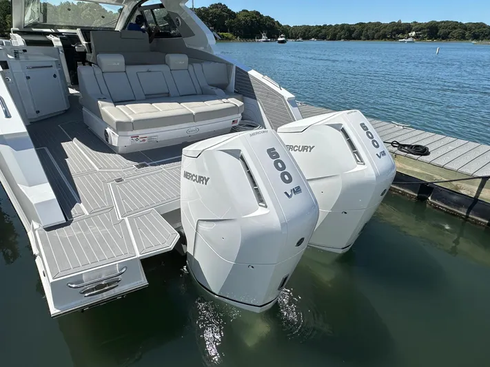  Yacht Photos Pics 2024 Cruisers Yachts 42 GLS Outboard with twin Mercury 600 V12 engines docked by a lake.