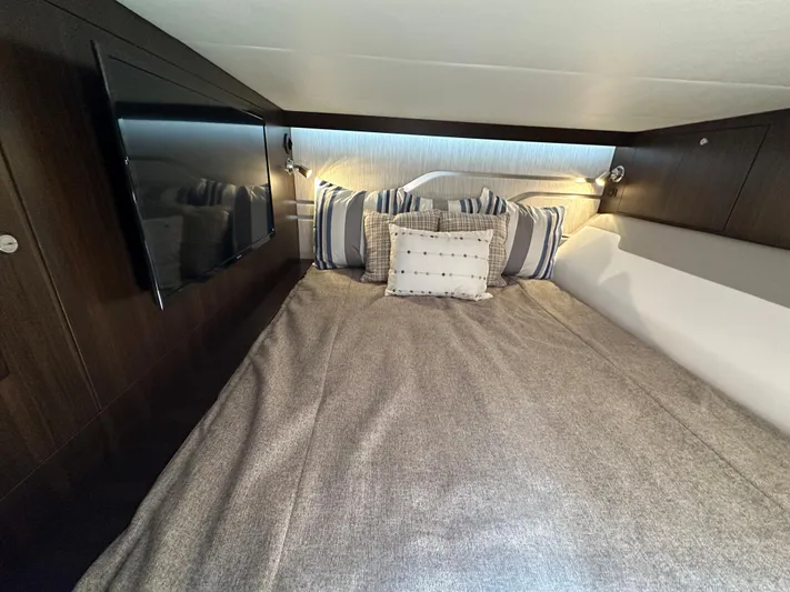  Yacht Photos Pics 2024 Cruisers Yachts 42 GLS Outboard cabin with cozy bed, pillows, and wall-mounted TV.