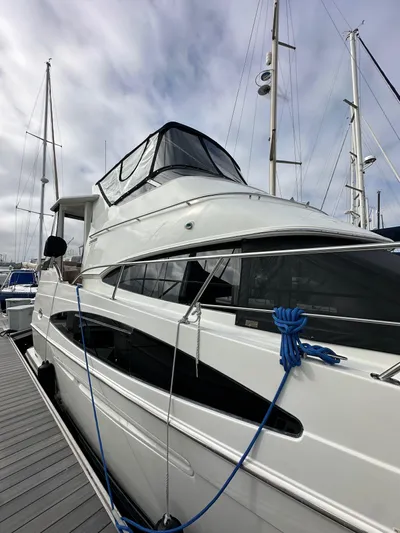 Paradigm Yacht Photos Pics 2004 Carver 366 Motor Yacht docked with blue ropes, under cloudy sky.