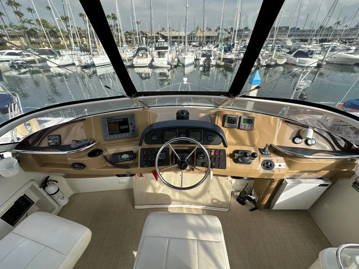 Paradigm Yacht Photos Pics 2004 Carver 366 Motor Yacht helm with marina view, featuring modern navigation equipment.