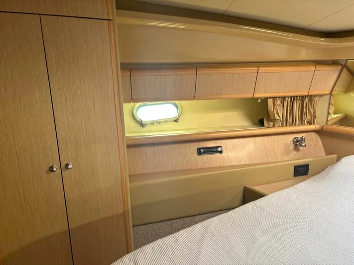  Yacht Photos Pics Luxurious cabin interior of 2005 Ferretti Yachts 530 with wood finish and porthole window.
