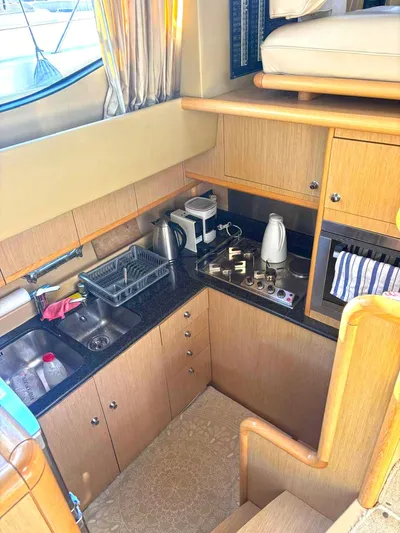  Yacht Photos Pics Compact kitchen in 2005 Ferretti Yachts 530 with modern appliances and wooden cabinetry.
