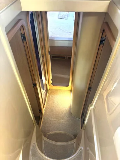  Yacht Photos Pics Narrow hallway inside 2005 Ferretti Yachts 530, featuring wooden doors and carpeted flooring.