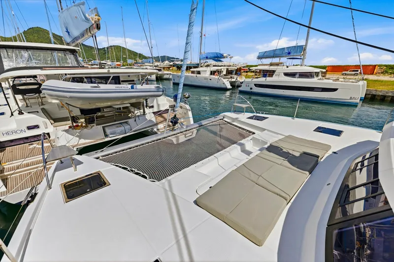 Nauti Mollie Yacht Photos Pics 2020 Fountaine Pajot Astrea 42 Catamaran docked in a marina, featuring spacious deck and netting.