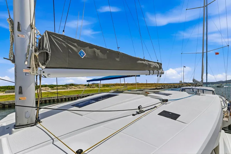 Nauti Mollie Yacht Photos Pics 2020 Fountaine Pajot Astrea 42 Catamaran deck with sails, docked by the shore.