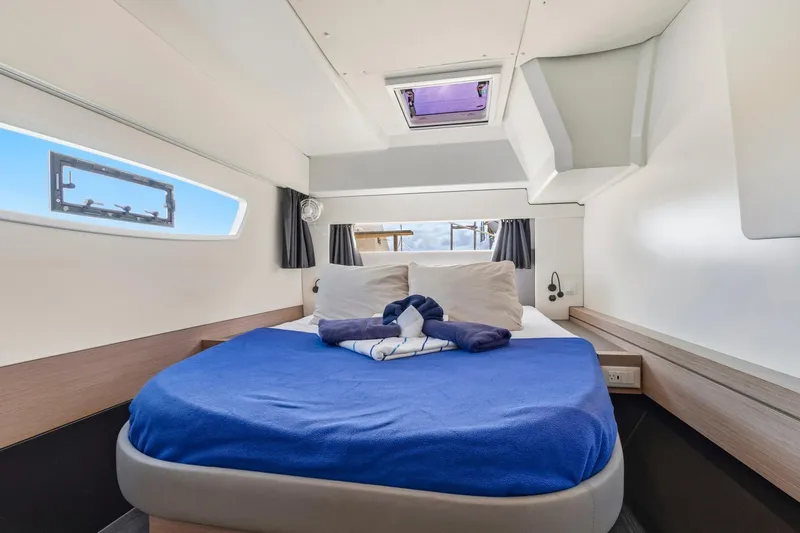 Nauti Mollie Yacht Photos Pics Luxurious cabin interior of 2020 Fountaine Pajot Astrea 42 Catamaran with cozy bed and window view.