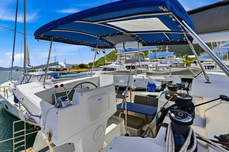 Nauti Mollie Yacht Photos Pics 2020 Fountaine Pajot Astrea 42 Catamaran docked, featuring spacious cockpit and blue canopy.