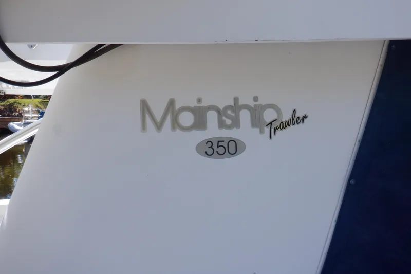 Seaglass Yacht Photos Pics 1999 Mainship 350 Trawler boat logo on white hull.