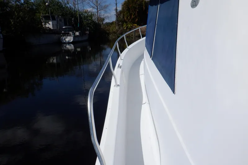 Seaglass Yacht Photos Pics 1999 Mainship 350 Trawler side deck view with railing, docked near other boats.