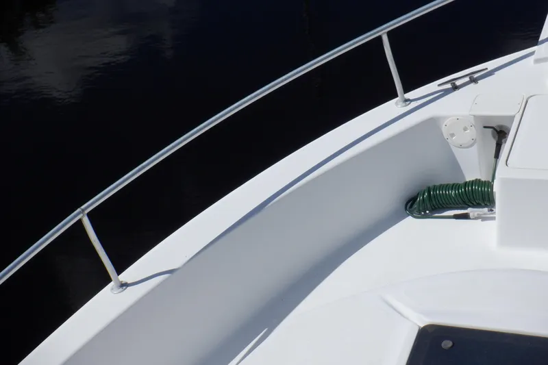 Seaglass Yacht Photos Pics 1999 Mainship 350 Trawler deck with railing and coiled green hose.