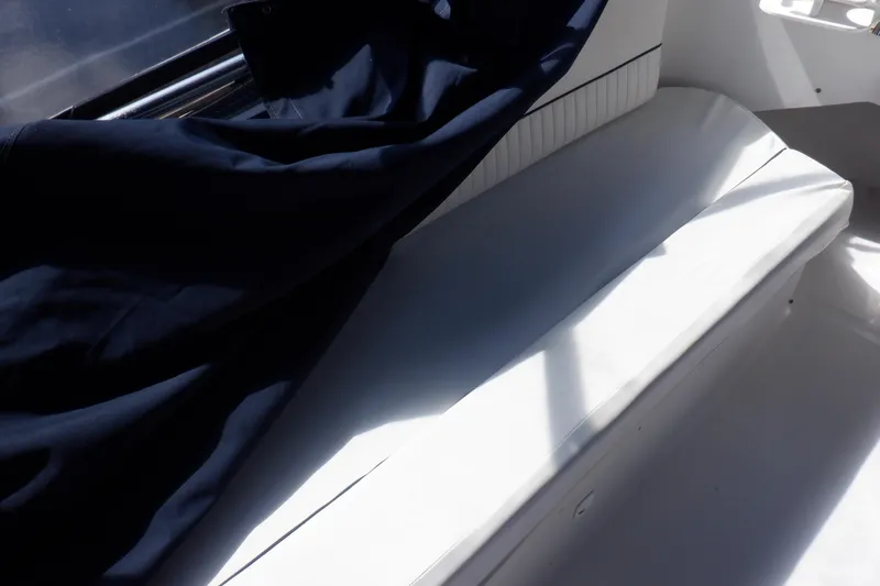 Seaglass Yacht Photos Pics White seating area on a 1999 Mainship 350 Trawler, partially covered by a dark fabric.