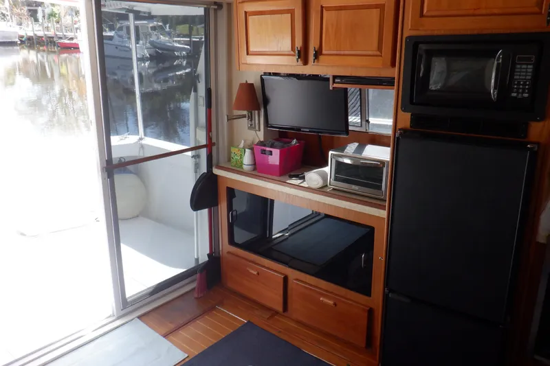 Seaglass Yacht Photos Pics 1999 Mainship 350 Trawler interior with kitchen appliances and sliding door to deck.