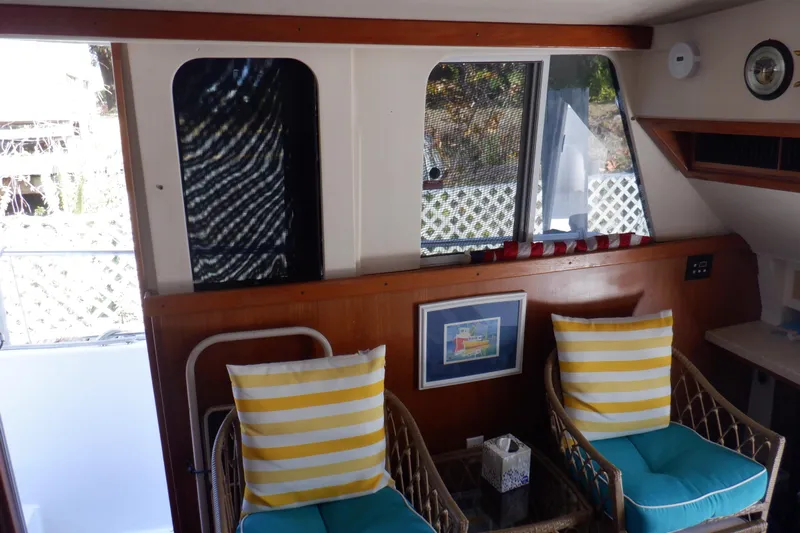 Seaglass Yacht Photos Pics Interior of 1999 Mainship 350 Trawler with wicker chairs and striped cushions.