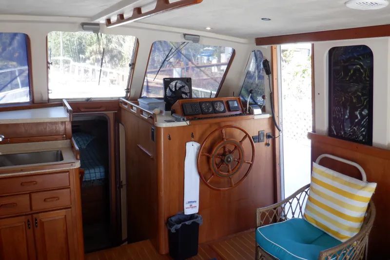 Seaglass Yacht Photos Pics 1999 Mainship 350 Trawler interior with wooden helm, seating, and cabin view.