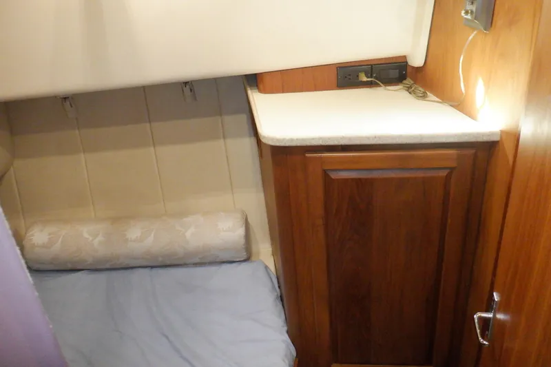 Seaglass Yacht Photos Pics 1999 Mainship 350 Trawler cabin interior with wooden cabinetry and cozy sleeping area.