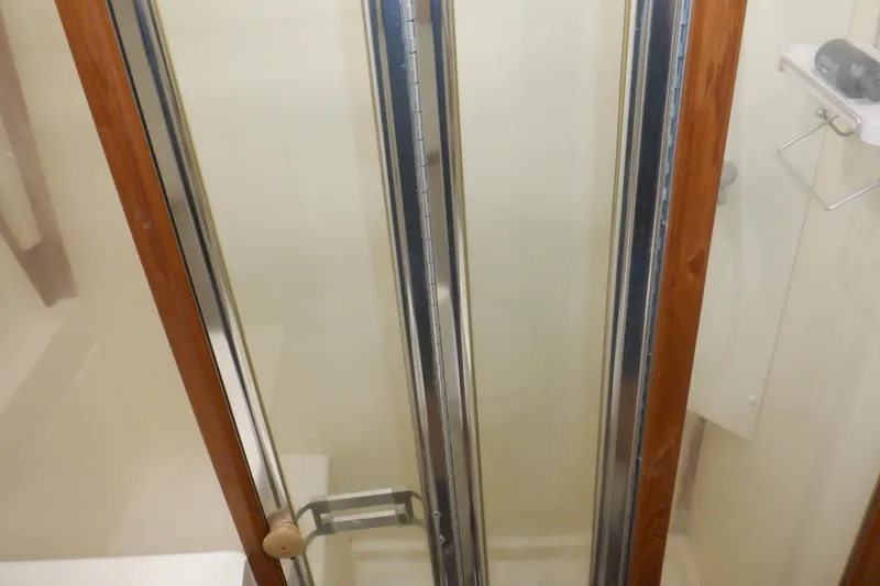 Seaglass Yacht Photos Pics Shower area inside 1999 Mainship 350 Trawler with glass door and wooden frame.
