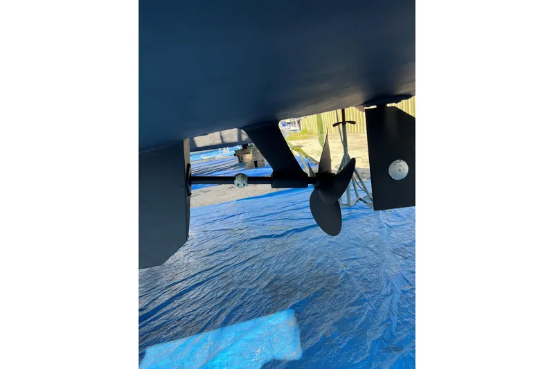 Seaglass Yacht Photos Pics 1999 Mainship 350 Trawler propeller and rudder on blue tarp background.