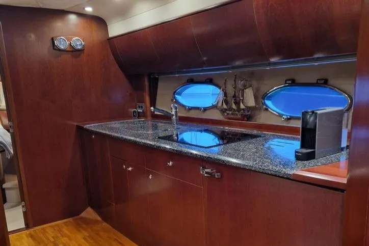  Yacht Photos Pics Luxurious 2006 Princess V58 yacht kitchen with sleek wood cabinetry and modern appliances.