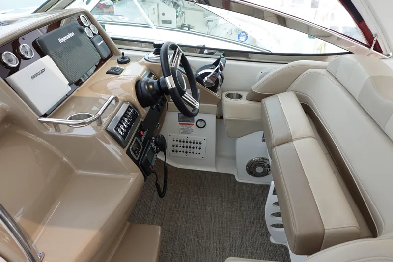  Yacht Photos Pics 2016 Formula 34 Cruiser helm with beige seating, steering wheel, and navigation equipment.