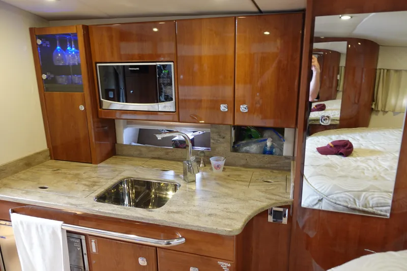  Yacht Photos Pics Luxurious kitchen area in a 2016 Formula 34 Cruiser yacht with wood cabinetry and modern appliances.