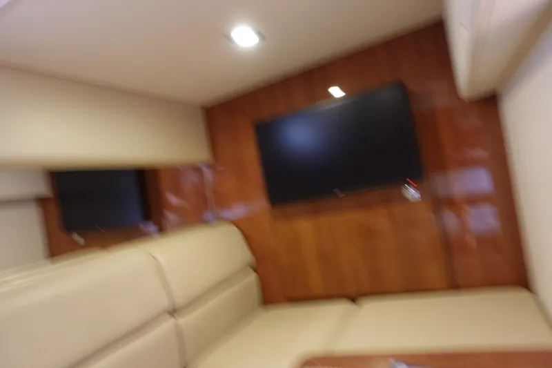  Yacht Photos Pics Blurry interior of 2016 Formula 34 Cruiser with beige seating and wall-mounted TV.