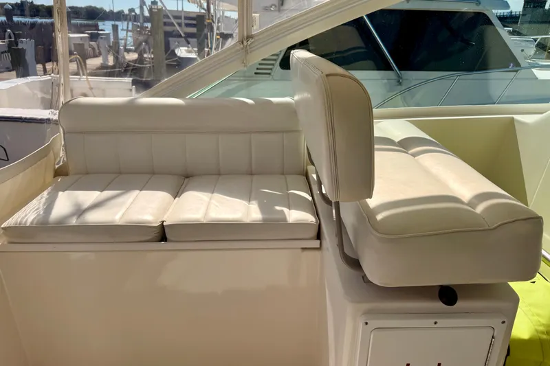  Yacht Photos Pics 2001 Cabo 35 Express boat interior with white cushioned seating in sunlight.