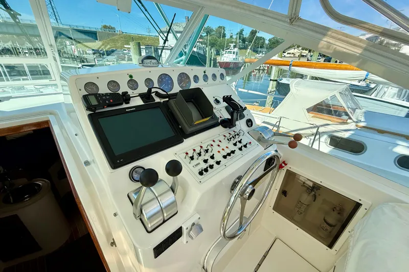  Yacht Photos Pics Control panel of a 2001 Cabo 35 Express boat, featuring navigation instruments and steering wheel.