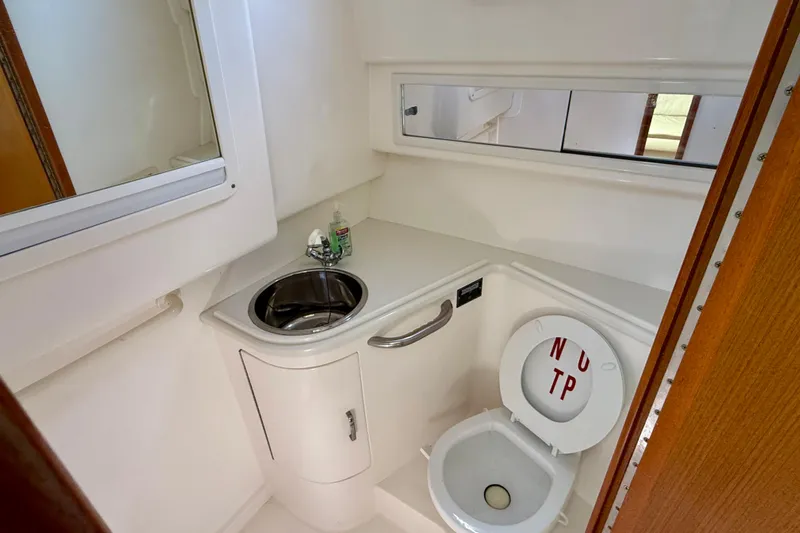  Yacht Photos Pics 2001 Cabo 35 Express boat bathroom with sink, mirror, and toilet.