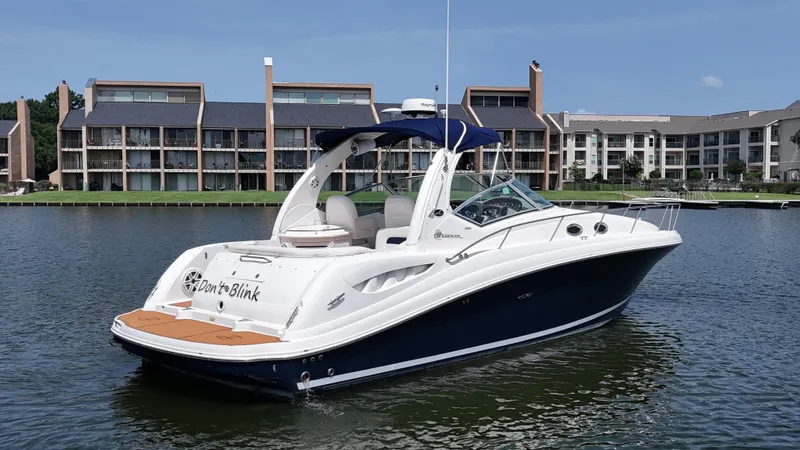 Don't Blink Yacht Photos Pics 2005 Sea Ray 340 Sundancer boat on water, with modern buildings in the background.
