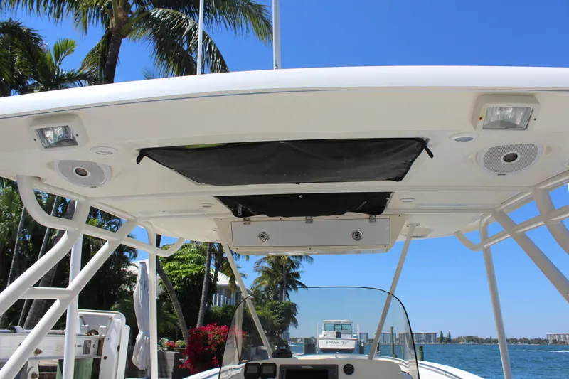  Yacht Photos Pics 2008 Pursuit S 310 Sport boat canopy with speakers and lights, docked near palm trees.