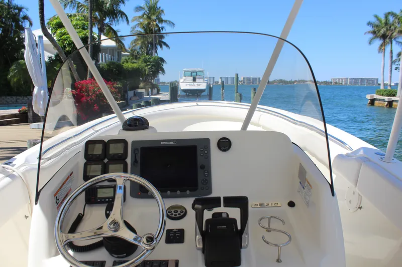  Yacht Photos Pics 2008 Pursuit S 310 Sport boat dashboard with steering wheel, controls, and waterfront view.