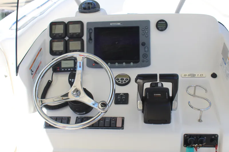  Yacht Photos Pics Control panel of a 2008 Pursuit S 310 Sport boat with steering wheel and navigation equipment.