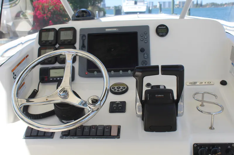  Yacht Photos Pics 2008 Pursuit S 310 Sport boat dashboard with steering wheel and navigation controls.