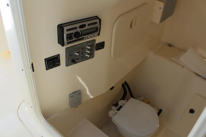  Yacht Photos Pics Interior of 2008 Pursuit S 310 Sport boat featuring a compact marine toilet and control panel.