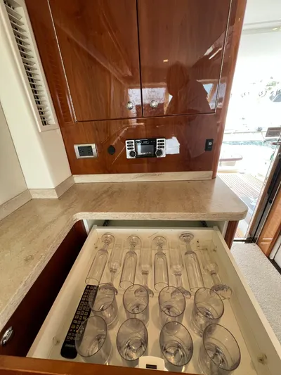 No Name Yacht Photos Pics Interior of 2016 Riviera 45 OPEN yacht with glassware drawer and wooden cabinetry.