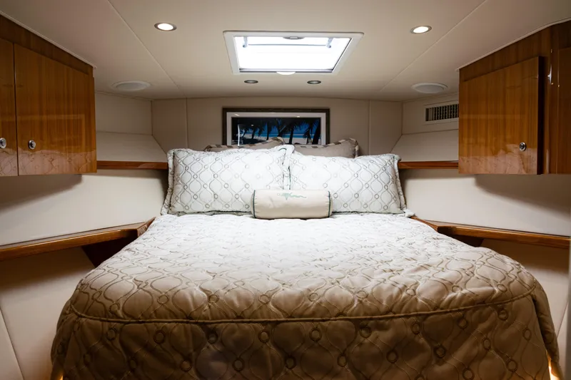  Yacht Photos Pics Luxurious cabin interior of 2021 Viking 44 Open yacht with cozy bedding and wooden cabinets.