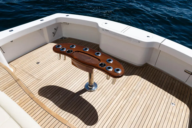  Yacht Photos Pics 2021 Viking 44 Open yacht deck with wooden table, surrounded by ocean water.