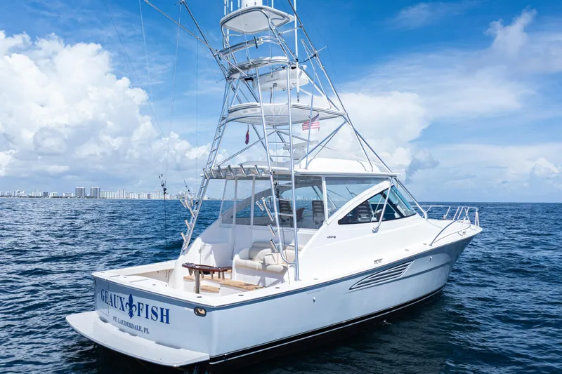  Yacht Photos Pics 2021 Viking 44 Open yacht on ocean, clear sky, city skyline in background.