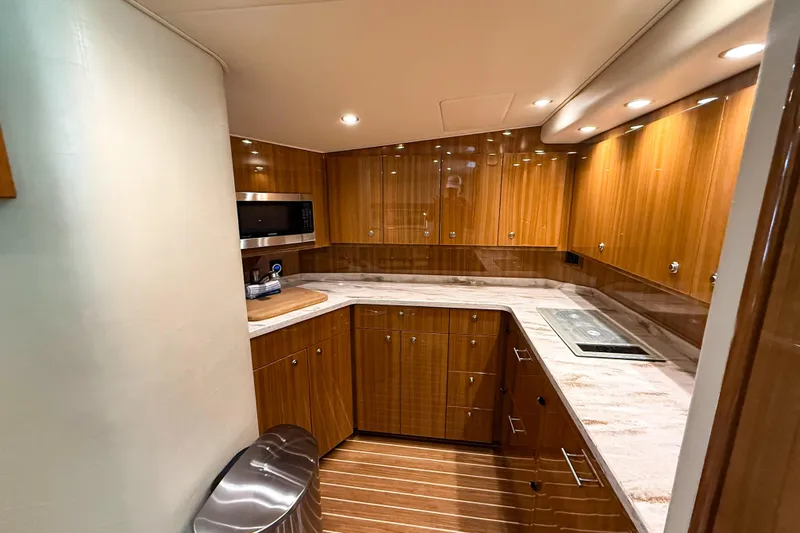  Yacht Photos Pics Luxurious kitchen interior of 2021 Viking 44 Open yacht with modern appliances and wood finish.