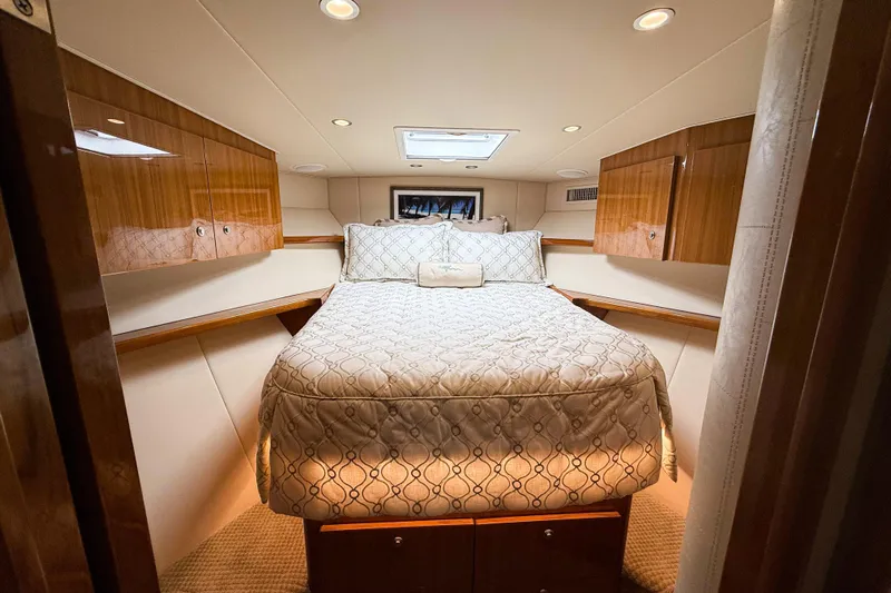  Yacht Photos Pics Luxurious cabin interior of 2021 Viking 44 Open yacht with elegant bedding and wood cabinetry.