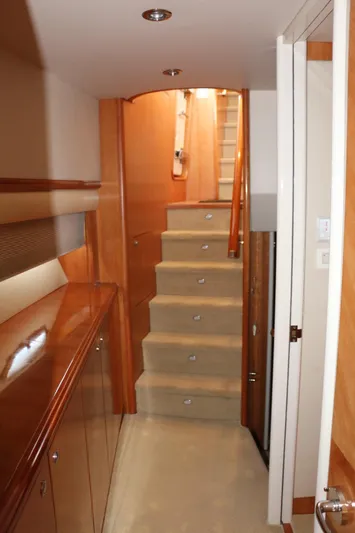  Yacht Photos Pics Interior of 2004 Cheoy Lee 68 yacht, featuring wooden cabinetry and carpeted stairs.