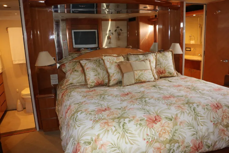  Yacht Photos Pics Luxurious bedroom interior of 2004 Cheoy Lee 68 yacht with floral bedding and wood accents.