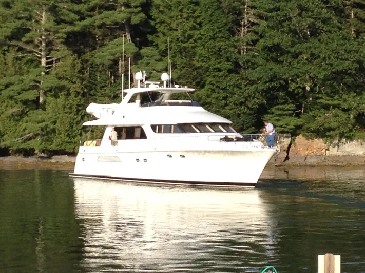  Yacht Photos Pics 2004 Cheoy Lee 68 yacht cruising near a forested shoreline.