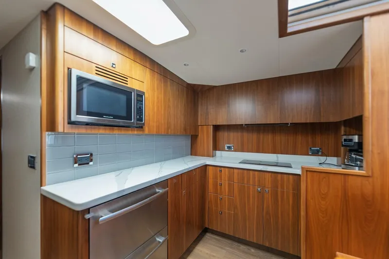 Reely Yacht Photos Pics Luxurious 2018 Hatteras GT45X Flybridge yacht kitchen with wood cabinetry and modern appliances.